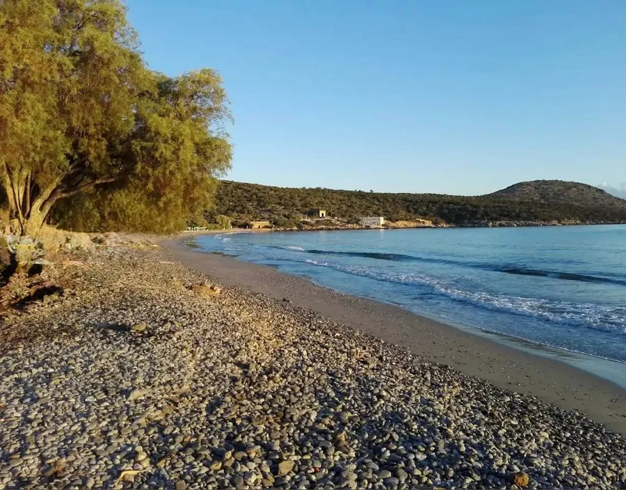 Long quiet beach with pebbles and patches of sand at Karavostasi Beach